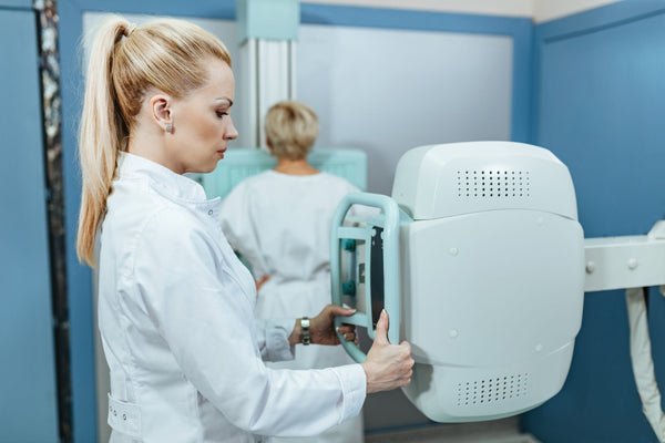 Female doctor taking X-ray of a patient in examination room at the hospital.
