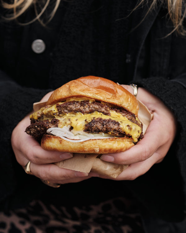 Person holding burger with patty