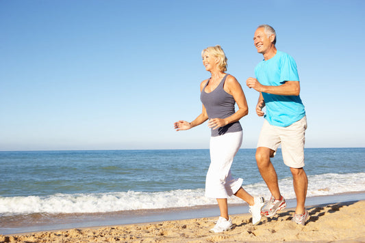 Senior,Couple,In,Fitness,Clothing,Running,Along,Beach